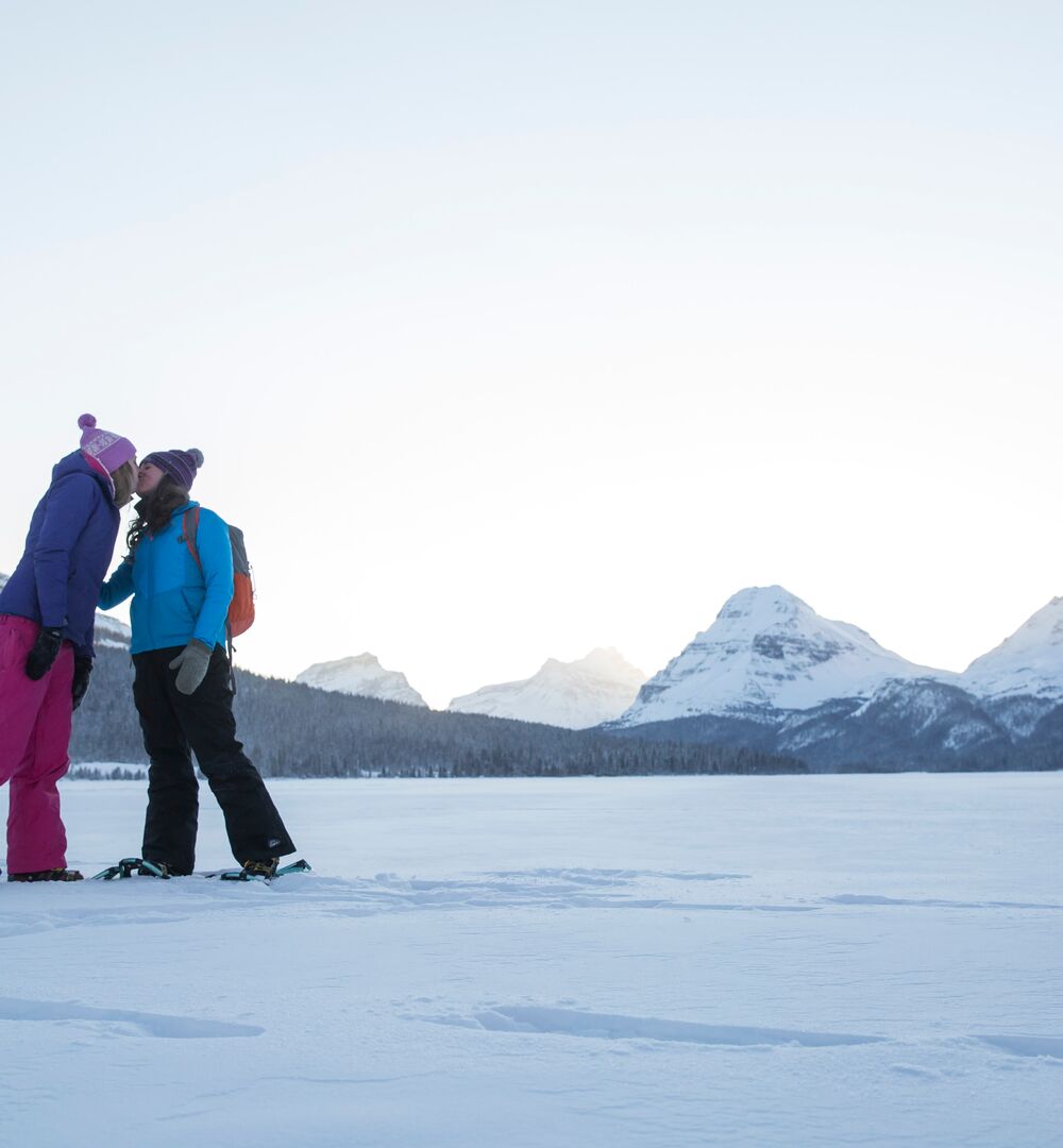 Two snowshoers share a kiss on Bow Lake on the Icefield Parkway in Banff National Park.